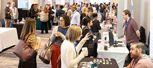 AMWA members engaged in conversation at an AMWA Annual Conference, showcasing collaboration and connection within the medical writing community